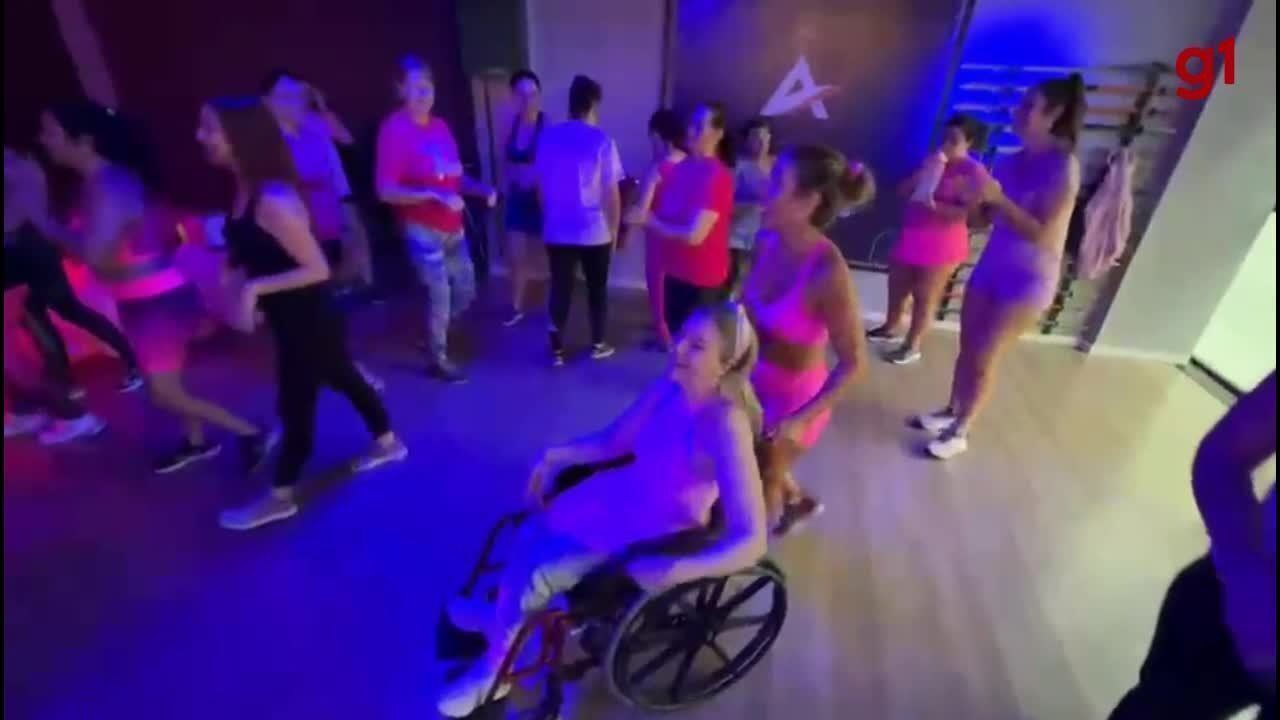 Participantes de aula de dança fazem trenzinho com aluna cadeirante em Florianópolis